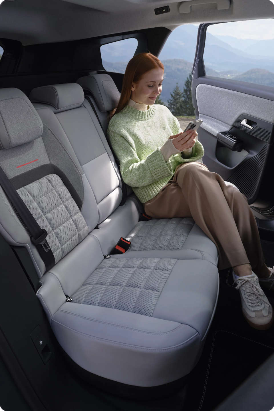 Молода жінка сидить на другому ряду сидінь у салоні Citroën C5 Aircross